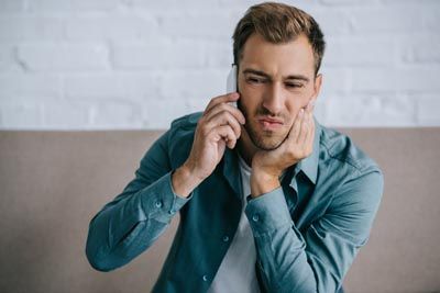 man on the phone scheduling an emergency dental appointment
