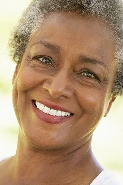 woman smiling after dental crowns helped restore her smile
