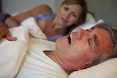 woman wide awake due to her husband's snoring from sleep apnea
